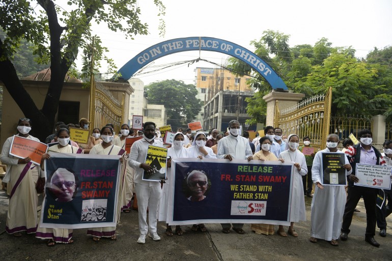 In this file photo from October 2020, Catholic priests and nuns hold placards during a protest in Secunderabad against the arrest of Jesuit priest Father Stan Swamy [File: Noah Seelam/AFP]