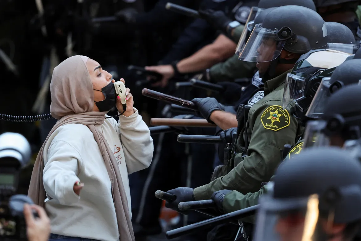 Demonstrators face off with law enforcement officers deployed to the University of California, Irvine (UC Irvine). [Mike Blake/Reuters]