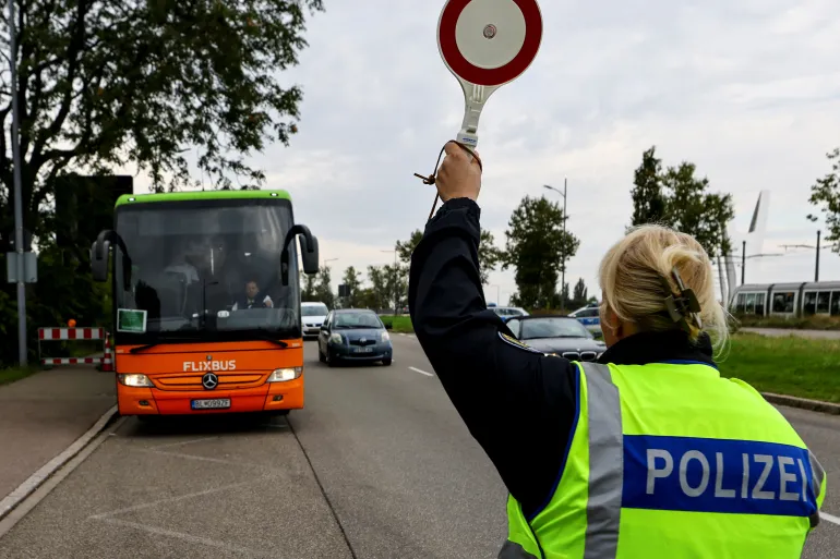 A German police officer stops a bus at the French border as Berlin imposes new border control measures in all of its neighbouring nine Schengen zone countries [Joachim Herrmann/Reuters]