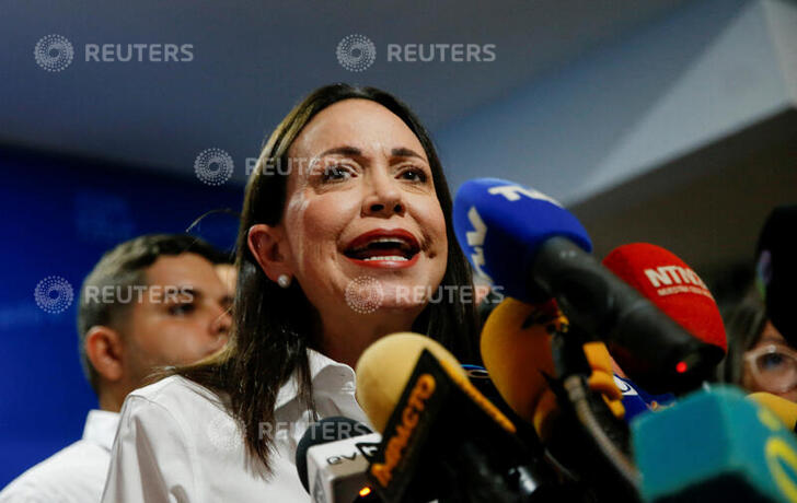 Venezuelan opposition leader Maria Corina Machado raises the hand of opposition presidential candidate Edmundo Gonzalez Urrutia during a rally in front of the United Nations headquarters in Caracas on July 30, 2024. © Yuri Cortez, AFP