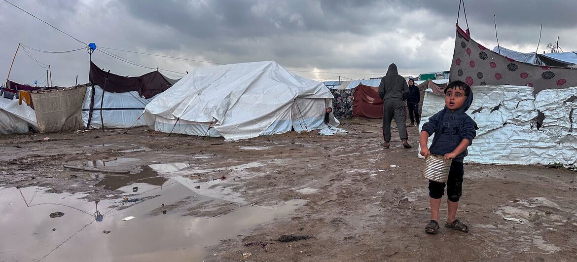 Archive © UNOCHA A young boy walks near tents in Jabalya, northern Gaza.