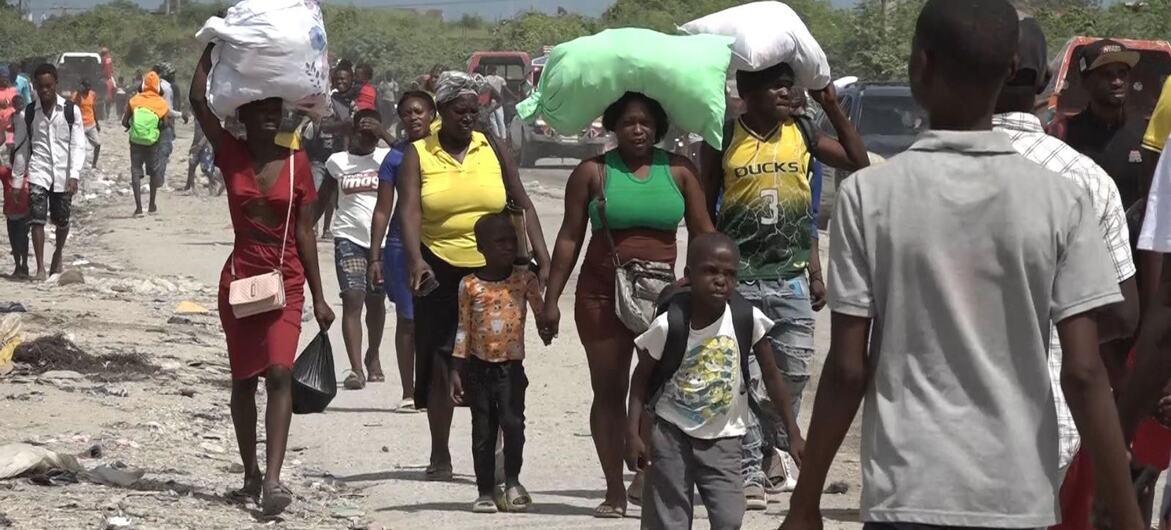 © WFP/Odelyn Joseph People who have fled their homes carry possessions through the streets of Haiti's capital, Port-au-Prince