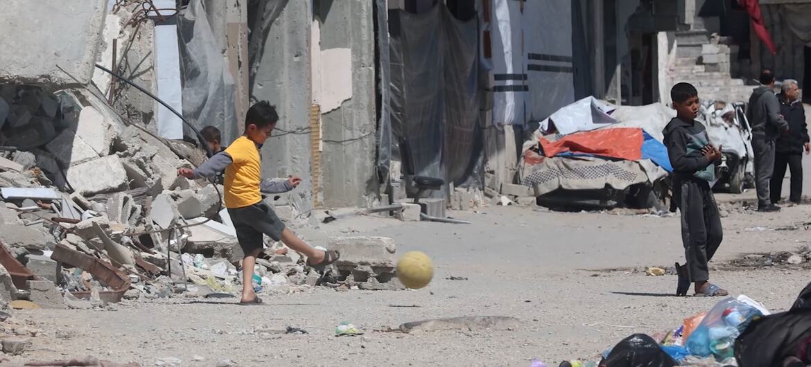 UN News Children play football amidst the rubble of Gaza City.