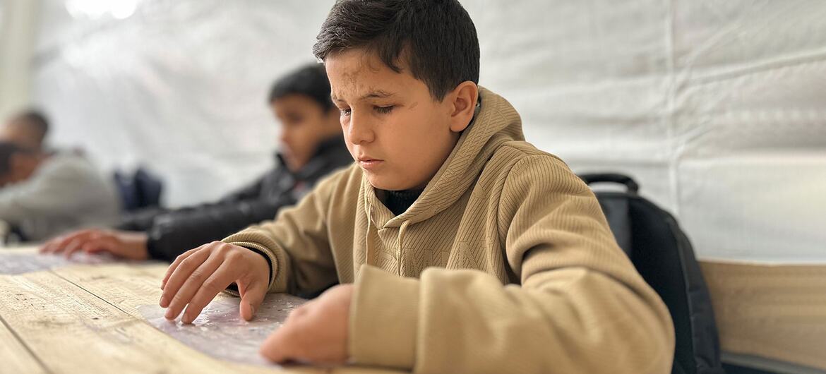 © UNRWA A child with visual impairment reads Braille at an education Centre in the Gaza Strip