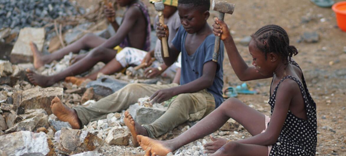 © UNICEF/Michael Songa A 12-year-old girl (right) made to work alongside her friends, also children, at a rock quarry in Sierra Leone
