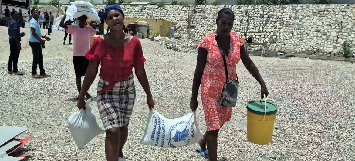 © WFP/Sylvain Barral Women in the Haitian capital, Port-au-Prince, who have fled their homes due to violence, carry relief aid.